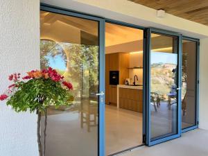 a glass door of a house with a vase of flowers at Newly renovated traditional Sardinian dwelling in Porto Rotondo