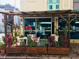een restaurant met een tafel en stoelen en bloemen bij Grand Mardin Hotel in Mersin