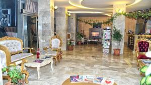 een woonkamer met stoelen en een open haard bij Grand Mardin Hotel in Mersin