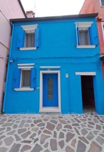 ein blaues Gebäude mit einer blauen Tür und Fenstern in der Unterkunft Ca Jole in Burano