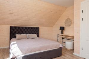 a bedroom with a large bed and a desk at Sodyba pas Brolius - Mažasis Namelis - Entire Barn House 85m2 in Priekulė