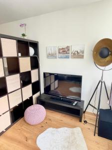 - un salon avec une télévision à écran plat à côté d'un mur dans l'établissement Vienna GoldMol Apartments Central, à Vienne