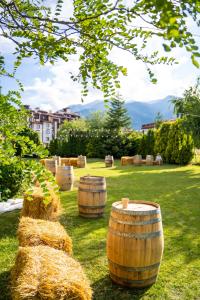 a group of wine barrels sitting in the grass at Parklands Hotel & Pool in Bansko