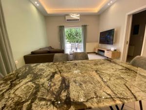 una sala de estar con una gran mesa de mármol con sillas en Comfortable Apartment Near to Metro & Hospitals en Atenas