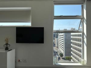 a living room with a large window with a flat screen tv at Studio corner unit in the heart of CBD in Cape Town