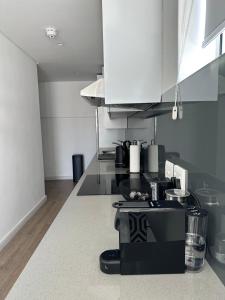 a kitchen with a black and white appliance on a counter at Studio corner unit in the heart of CBD in Cape Town