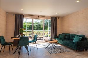 uma sala de estar com um sofá verde e uma mesa em Sodyba pas Brolius - Mažasis Namelis - Entire Barn House 85m2 em Priekulė