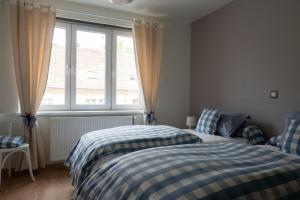 a bedroom with two beds and a window at A l Orée du Bois in Rimbach-près-Masevaux