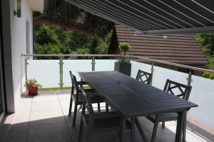 a black table and chairs on a balcony at A l Orée du Bois in Rimbach-près-Masevaux