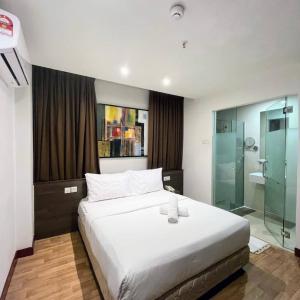 a bedroom with a large bed and a glass shower at Frenz Hotel Kuala Lumpur in Kuala Lumpur
