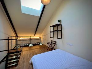 a bedroom with a white bed and a staircase at DoSomething Guest House 2 in Ipoh