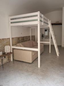 Litera blanca con sofá y escalera en Monolocale ai cavallucci, en Terracina
