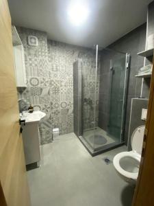 a bathroom with a shower and a toilet and a sink at Apartment DELS in Zenica
