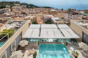 - une vue aérienne sur un bâtiment avec une piscine dans l'établissement NH Collection Taormina, à Taormine