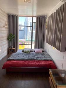 a bed in a room with a large window at H-HOMESTAY CONTAINER LAGI BEACH in Lagi