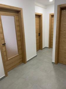 pasillo con puertas de madera y suelo de baldosa en Apartment DELS en Zenica