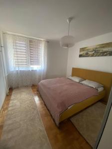 a bedroom with a bed and a window at Apartment DELS in Zenica
