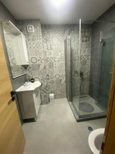 y baño con ducha y lavamanos. en Apartment DELS en Zenica