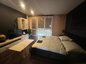 1 dormitorio con 1 cama y TV de pantalla plana en Green Penthouse, en Tiszaújváros