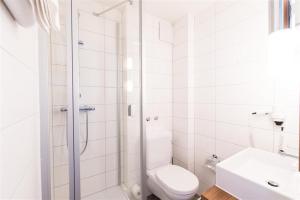 a white bathroom with a shower and a toilet at City Hotel Biel Bienne Free Parking in Biel