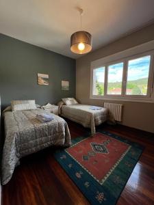 a bedroom with two beds and a rug on the floor at Casa Lola in Teo