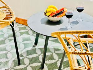 een tafel met een fruitschaal en twee glazen wijn bij Canaryislandshost l Mar in Puerto del Carmen