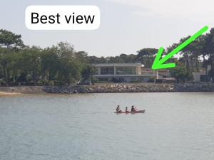 dwie osoby w łodzi na wodzie z zielonym x w obiekcie Waterfront amazing view w mieście Mimizan