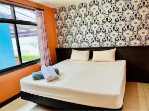 una camera da letto con un letto e due asciugamani di นฤมล วิลล่า ชะอำ a Petchaburi