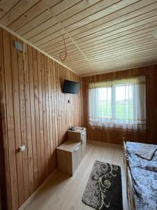 a small room with a bed and a tv in it at AVALON - Котедж на озері in Borysxaw