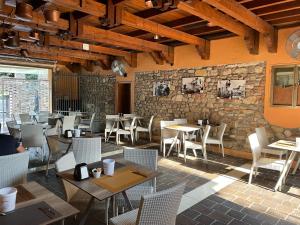 a restaurant with tables and chairs and a stone wall at Albergo Tecla in Lazise