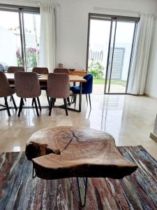 Luxury Villa sea view في أغادير: غرفة مع طاولة وكراسي وعقب خشبي على الأرض