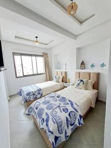 - une chambre avec 2 lits avec des draps bleus et blancs dans l'établissement Luxury Villa sea view, à Agadir