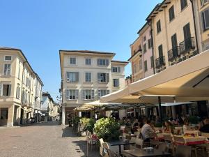 eine leere Straße mit Tischen, Stühlen und Gebäuden in der Unterkunft D-Place Apartment Piazza Duomo Crema in Crema