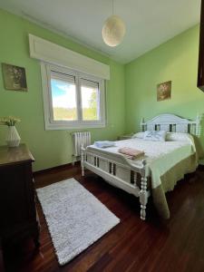 a bedroom with a white bed in a green room at Casa Lola in Teo