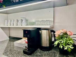 a coffee maker sitting on a counter next to flowers at D-Place Apartment Piazza Duomo Crema in Crema