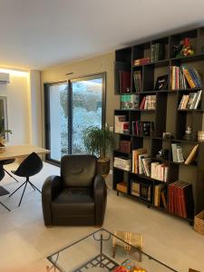 a living room with a chair and book shelves at Bread et Couette in Lyon