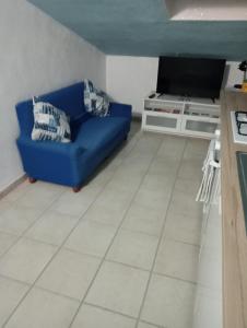 sala de estar con sofá azul y TV en casetta al mare, en Sapri