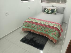 a bed with a blanket on it with a rug at Lotus Accommodation in Kingsburgh