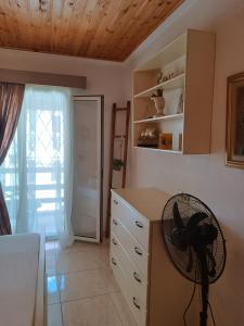 a kitchen with a desk with a fan and a window at Niki Apartments Sea View Attic in Platamonas