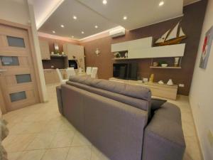 a living room with a couch and a kitchen at Scirocco Home in Marsala