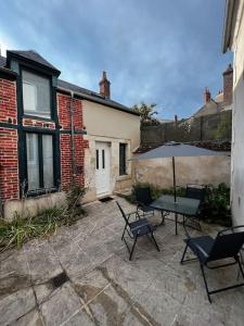 a patio with chairs and a table and an umbrella at Appartement T2 avec terrasse proche cathédrale in Bourges