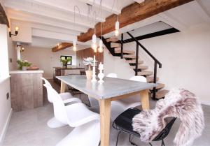 uma sala de jantar com uma mesa e cadeiras brancas em Green Cottage Luxury Stay Peak District near Alton Towers em Stanton