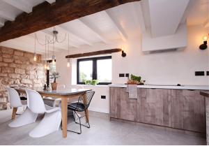 uma cozinha e sala de jantar com uma mesa de madeira e cadeiras em Green Cottage Luxury Stay Peak District near Alton Towers em Stanton