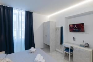 a room with a bed and a desk and a bathroom at AFFITTACAMERE ELENA in Sanremo