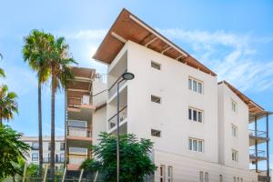 a building with palm trees in front of it at Résidence Pierre & Vacances Premium Port Prestige in Antibes