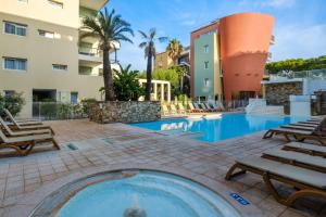 a swimming pool with lounge chairs and a building at Résidence Pierre & Vacances Premium Port Prestige in Antibes