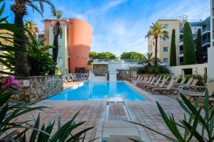 a pool at a hotel with chairs and trees at Résidence Pierre & Vacances Premium Port Prestige in Antibes