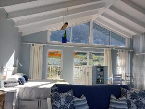 a bedroom with a bed and a blue couch at The Trailhouse in Bettyʼs Bay