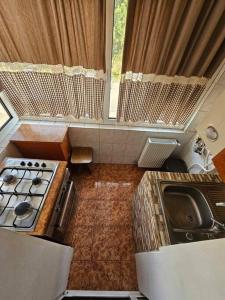 uma pequena cozinha com um fogão e um lavatório em Apartament Rebeca Central em Târgu Jiu