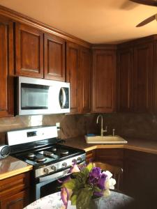 a kitchen with wooden cabinets and a stove top oven at Room to share in South Ozone Park